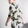 Camisas de manga curta com botões e estampadas com motivos botânicos