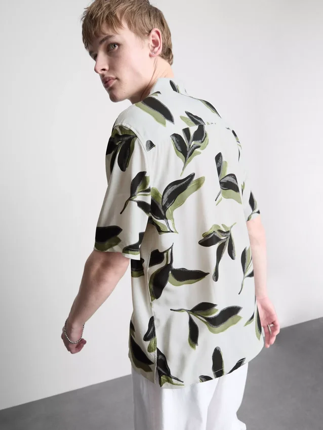 Camisas de manga curta com botões e estampadas com motivos botânicos