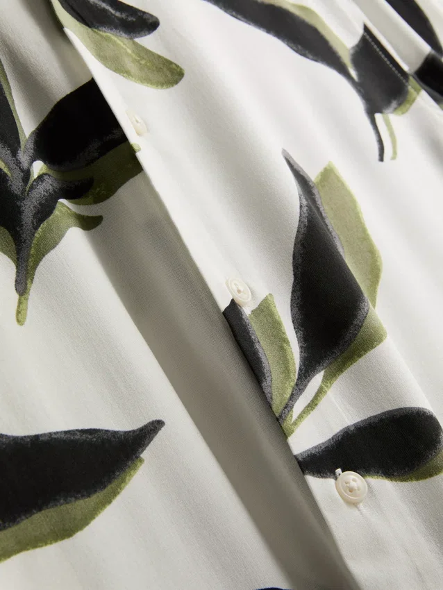 Camisas de manga curta com botões e estampadas com motivos botânicos